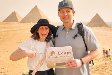 A picture of a couple in front of the Great Pyramids of Egypt Giza